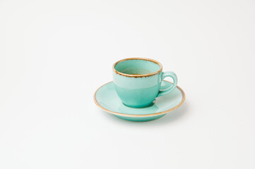 Isolated on white shot of a turquoise cup and saucer with a little espresso.