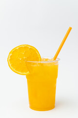 Vertical shot of some fresh made orange juice with some ice cubes in glass.