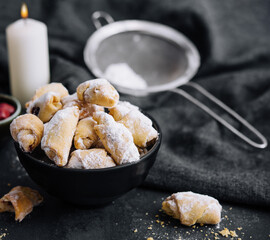 Homemade fresh cookies dusted powdered sugar in black plate