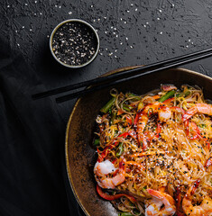Stir fry noodles with vegetables and shrimps in black bowl