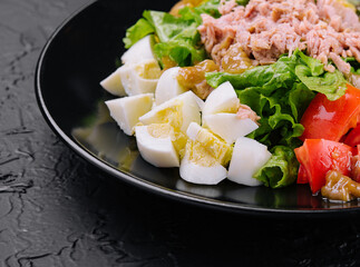Tuna and vegetable salad on black plate