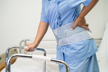 Asian lady patient use walker in hospital to support walking.