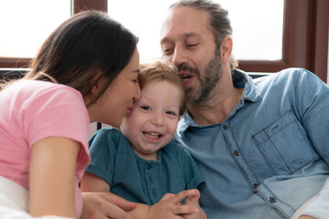 After the little boy wakes up from his nap, his father and mother engage in enjoyable activities in his bedroom.
