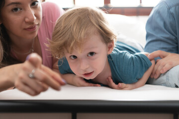 After the little boy wakes up from his nap, his father and mother engage in enjoyable activities in his bedroom.