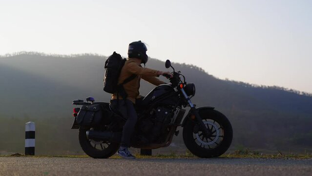 Caucasian male riding motorcycle in background of mountains