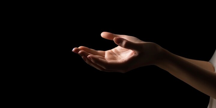 Woman hands praying for blessing from Allah. Beautiful woman's hand isolated on black background. Elegant woman hand with empty palm up