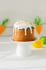 Traditional Ukrainian cake on a stand on a white tablecloth. The concept of festive Easter baking. Selective focus. Vertical orientation.