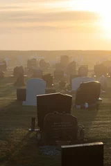 Foto op Plexiglas Historisch monument Vertical shot of cemetery tombstone graves at sunrise