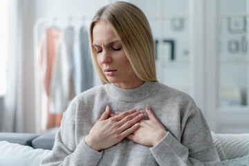 portrait of woman suffering from chest pain indoors