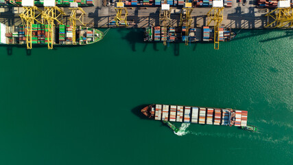 Fototapeta na wymiar container ship and commercial dock load and unloading cargo from container ship import and export by crane for distributing goods by trailers transportation, aerial top view