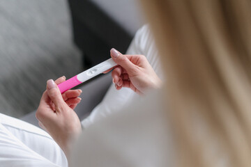 cropped shot of woman holding pregnancy test