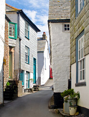 A picturesque narrow street with white-washed houses with painted doors and windows in Port Isaac, Cornwall