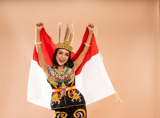 asian woman in traditional clothes of dayak tribe standing with smile and grabing the indonesian...