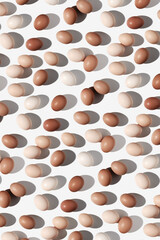 Easter eggs trend pattern with beige gradient colored eggshell, hard Shadow at sunlight, white background. Chicken eggs layout, top view, minimal flat lay, holiday food still life photo