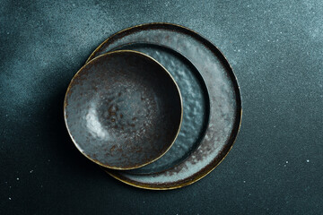 Empty gray plate (ceramic) set on a dark gray background. Free space for text. Top view.