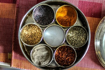 Top view of an Indian traditional masala box with various spices