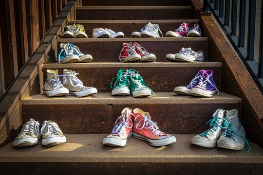 Number of colorful Converse All-stars sneakers on wooden stairs outdoors