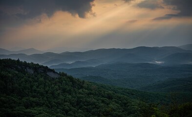 Aerial view of blue Ridge mountain landscape surrounded by dense trees during sunset