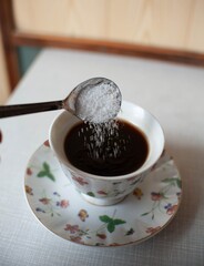 Sugar falling on the cup of coffee