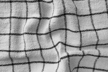 Classic black and white checkered kitchen towel texture. Crumpled fabric textile background with...