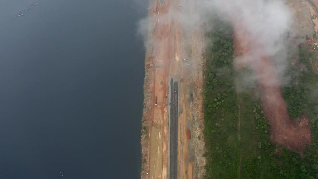 Aerial view with clouds of railway along the bank of a river in Ghana