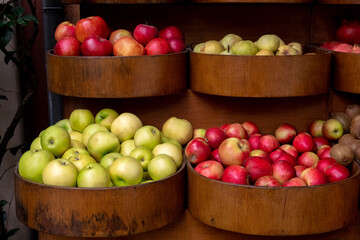 Fresh ripe red and green apples in wooden basket on farm market. Organic fresh fruits. Healthy eating concept.