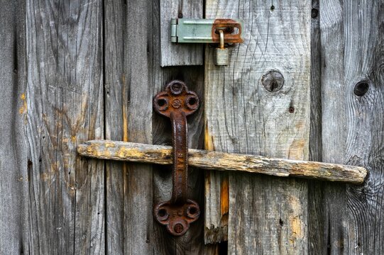 Closeup of a wooden locked door with rusty lock