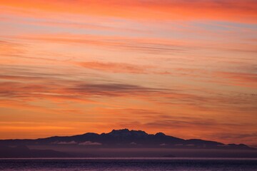 Aerial view of beautiful mountains near the ocean in Vancouver, Canada at sunset
