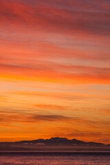 Vertical shot of beautiful mountains near the ocean in Vancouver, Canada at sunset