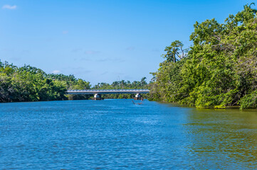 A view towards a bridge over the Belize River in Belize from the sea on a sunny day