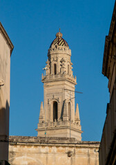 Fototapeta na wymiar Campanario de la catedral de Lecce, Italia, en la plaza del mismo nombre desde la calle Dasumno. Construido entre 1659 y 1670 por Giuseppe Zimbalo, con cinco pisos y una altura total de 70 m.