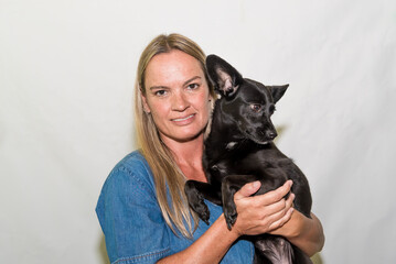 A woman holding a black dog in her arms adoption dog grooming