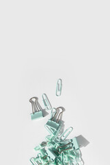 Stationery, paper clips, binders, buttons on a white background. Top view, flat lay