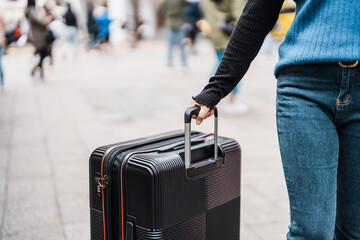 Traveler carrying suitcase luggage at outdoor destination..