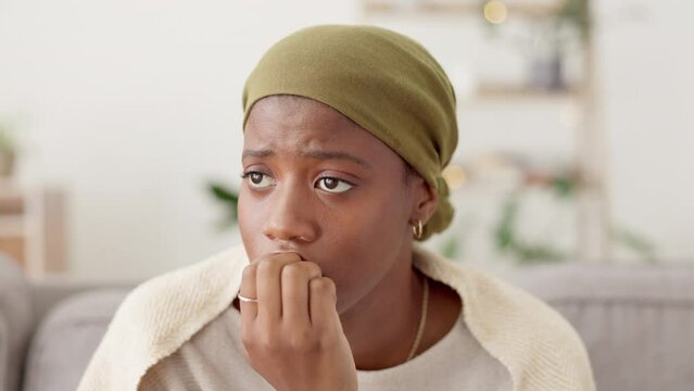 Stress, anxiety and nail biting by black woman of a sofa, worried and paranoid in her home. Fear, depression and girl with mental health problem in a living room, lonely and sad, afraid and crisis