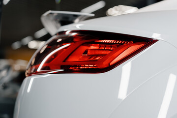 Close-up detail of the headlights of a white luxury modern car The concept of passion for driving car showrooms