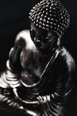 Meditating Buddha Statue on dark background. Soft focus. Close up. Copy space.	