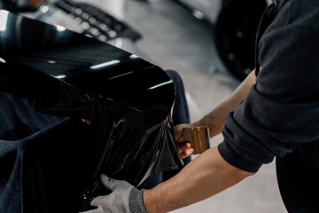 Gluing the film on the spoiler to protect the paint which protects the paint from scratches and...