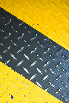 Fondo con detalle y textura de superficie metalica con pintura en tonos negro y amarilo