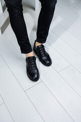 Male legs in black jeans close-up in black leather casual sneakers. Comfortable men's demi-season shoes