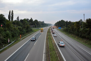 Fototapeta premium Traffic on the expressway. In the background, a remote control of the autobahn with the use of trucks and construction equipment. View from above