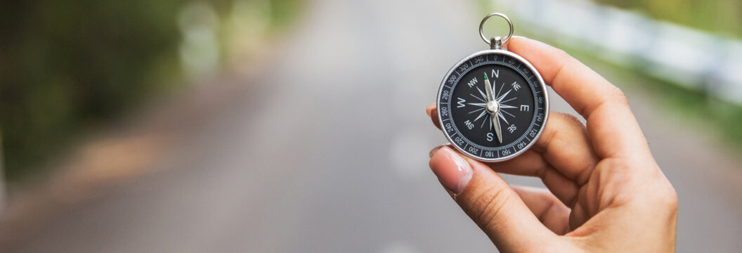 woman holding compass in road background