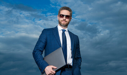 businessman with laptop on sky background. businessman with laptop outdoor