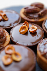 Set of delicious shortbread cakes decorated with dark chocolate and nuts. Tasty little desserts cooked in a pastry cafe for lunch