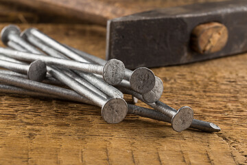Vintage hammer with nails on wood background