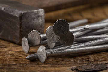 Vintage hammer with nails on wood background