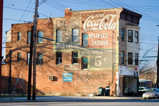 Schenectady, NY, USA: Large, Coca-Cola Hand-painted Advertising Sign On Side Of Three Story, Brick Building Illuminated By Evening Sun. Showing Full Building, Golden Sun, Shadows.