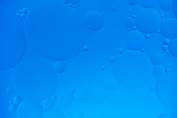 Blue abstract background with oil circles, streaks and gradient.