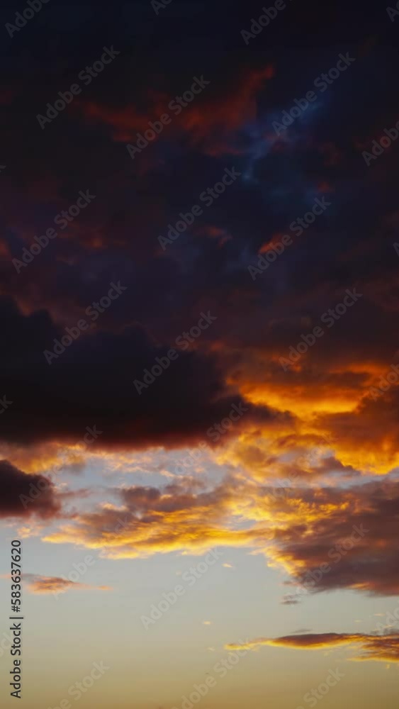 Wall mural timelapse with dramatic red sunset on dark cloudy sky. vertical video