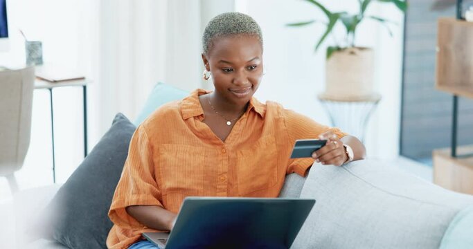 Laptop, online shopping and smile with a black woman and a credit card in her home. Computer, payment and banking with a female customer using the internet to search an ecommerce sale on a sofa